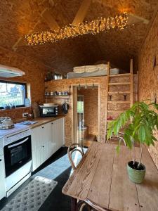 a kitchen with a wooden table with a potted plant at Domaine de Hurlevent - Tiny House petite maison écologique in Aywaille