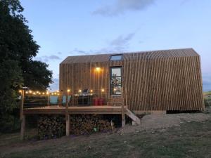 a small wooden house with a wooden deck at Domaine de Hurlevent - Tiny House petite maison écologique in Aywaille +14 photos
