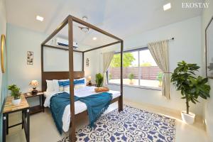 a bedroom with a canopy bed and a window at EKOSTAY - Pinewood Villa in Alibaug +14 photos