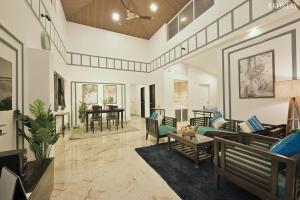 a living room with a couch and chairs at EKOSTAY - Pinewood Villa in Alibaug