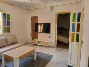 a living room with a couch and a flat screen tv at Akwaba lodge in Salé +77 photos