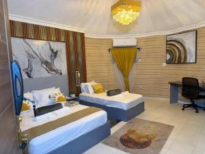 a room with two beds and a desk in it at Chic Premium Hotel in Durocher