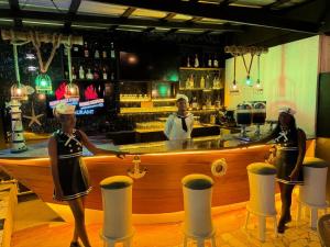 three women standing in front of a bar at Chic Premium Hotel in Durocher