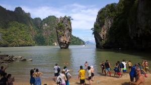 a group of people standing on a beach near a body of water at U Sabai Living Hotel in Patong Beach