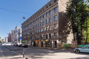 een groot gebouw in een stadsstraat met auto's buiten geparkeerd bij Luxury Design Apartment Riga in Rīga