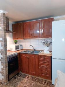 a kitchen with wooden cabinets and a sink at Тиха гавань в чарівному містечку in Korsun'-Shevchenkivs'kyy