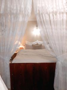 a bedroom with a bed with white curtains at Тиха гавань в чарівному містечку in Korsun'-Shevchenkivs'kyy