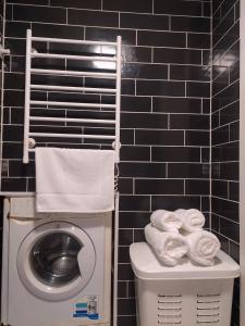 a bathroom with a washing machine and towels on a toilet at Тиха гавань в чарівному містечку in Korsun'-Shevchenkivs'kyy