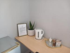 a table with a coffee maker and a plant on it at Red Hills Guesthouse in Tsumeb