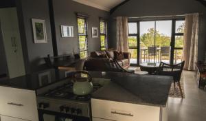a kitchen with a stove and a living room at Essea House in Wilderness +18 photos