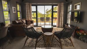 a living room with a couch and chairs and a table at Essea House in Wilderness