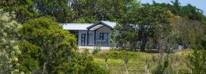 a house in the middle of a field with trees at Essea House in Wilderness