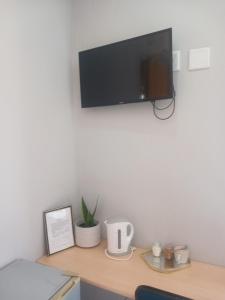 a desk with a tv on a wall at Red Hills Guesthouse in Tsumeb