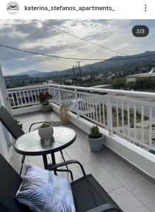 Un patio con una mesa y sillas en un balcón. en Katerina family Apartment, en Archangelos