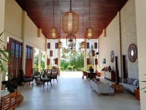 DehegilaMarahai Villa Morotai的一个宽敞的客厅，里面有沙发、椅子和一个钟。