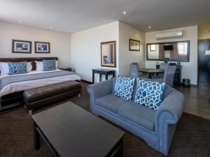 ein Hotelzimmer mit einem Bett und einer Couch in der Unterkunft ANEW Hotel Witbank Emalahleni in Witbank
