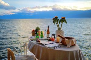 a table with food and drinks on top of the ocean at LIUBAI HANDANYI Seaview Resort Hotel in Dali Shuanglang