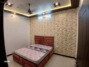 a bedroom with a bed in the corner of a room at Green Valley Residency in Lucknow +2 photos