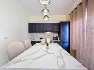a kitchen with a table with chairs and a blue refrigerator at Peaceful Home with Private Pool and Rooftop Jacuzzi in Xagħra