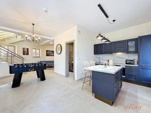 a kitchen with blue cabinets and a ping pong table at Peaceful Home with Private Pool and Rooftop Jacuzzi in Xagħra +38 photos