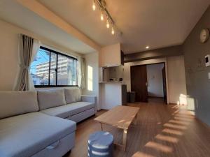 ein Wohnzimmer mit Sofa und Tisch in der Unterkunft In time tokyo in Ichikawa