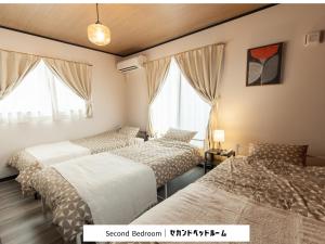 a bedroom with three beds and two windows at 貸切新築ヴィラ l 最大9名 l 小田原城徒歩14分 l 無料P l 箱根板橋駅徒歩9分 l SENU VILLA Minamicho - Odawara in Odawara