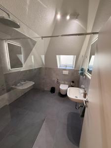 a bathroom with two sinks and a toilet at Pension Elisa in Bad Friedrichshall +11 photos