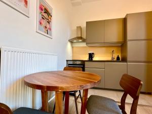 a kitchen with a wooden table and chairs in a room at Luxury Suites Royal by Rikas Hotels in Antwerp