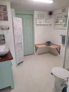 een badkamer met een toilet en een tafel en een deur bij Forest view bungalow in Nambucca Heads +75 foto's