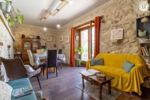 ein Wohnzimmer mit einem gelben Sofa und einem Tisch in der Unterkunft La grange du paris in Saint-Pierre-dʼAlvey