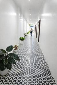 a hallway with black and white tiled floors and plants at King Hotel Hải Phòng in Hai Phong