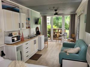 een keuken en een woonkamer met een bank en een magnetron bij Forest view bungalow in Nambucca Heads