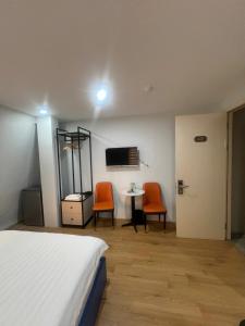 a bedroom with a bed and two chairs and a table at Netcoe Hotel in Hanoi