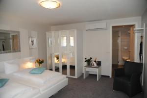 een slaapkamer met een bed, een stoel en een spiegel bij Hotel Adler - Weil am Rhein in Weil am Rhein