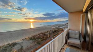een balkon met uitzicht op het strand bij zonsondergang bij Exceptional sea view! Comfortable apartment in La Celle-sous-Gouzon