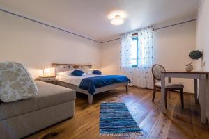 a bedroom with a bed and a desk and a chair at Casa Krasna Gourmet Boutique Hotel in Lokev