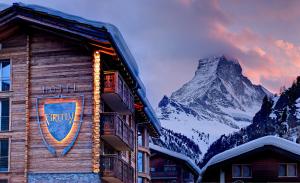 a sign on the side of a building with a mountain at Firefly Luxury Suites in Zermatt