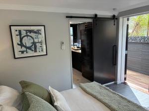 a living room with a couch and a sliding glass door at Courtyard Pool Studio Private Luxe Retreat in Coal Point