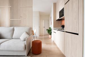 a living room with a white couch and a kitchen at Líbere Seville Plaza Nueva in Seville +64 photos