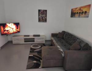 een woonkamer met een bank en een tv bij Dimora MALÈ in San Pietro Vernotico