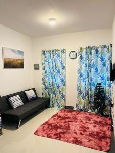 a living room with a black couch and a red rug at Selah Stay in Manolo Fortich