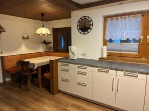 a kitchen with white cabinets and a table and a window at Jagerhäusl in Fügen +23 photos