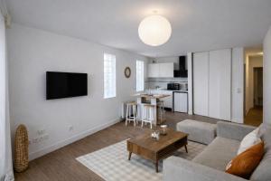 un soggiorno con un divano e un tavolo di Vaste studio 3 personnes avec balcon et parking a La Teste-de-Buch Altre 18 foto