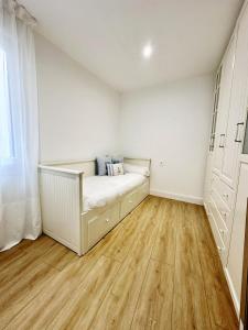 een slaapkamer met een bed en een houten vloer bij Mundaka Centre 2 in Mundaka +1 foto