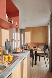 a kitchen with a counter and a table with fruits on it at Camping O'Aka in Leyme