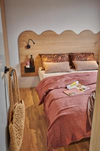 a bedroom with a large bed with a wooden headboard at Camping O'Aka in Leyme