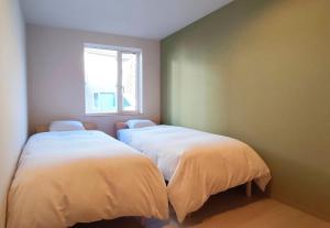 Postel nebo postele na pokoji v ubytování Niseko Izumikyo