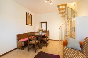 uma sala de jantar com uma mesa e uma escada em espiral em Casa Nico Magognino - WiFi em Stresa