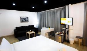 a room with a bed and a couch and a tv at My Room by Sermsub in Aranyaprathet