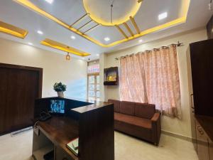 een woonkamer met een bank en een televisie bij Hotel Santosh Heritage in Pushkar